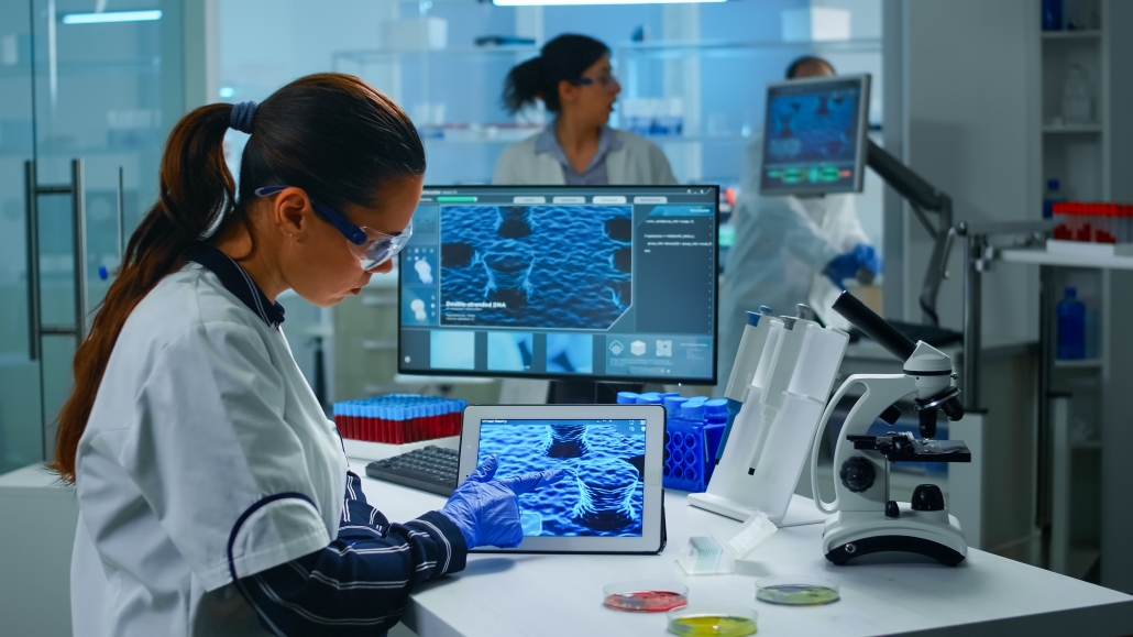 Lab technician doctor analyzing virus evolution looking on digital tablet